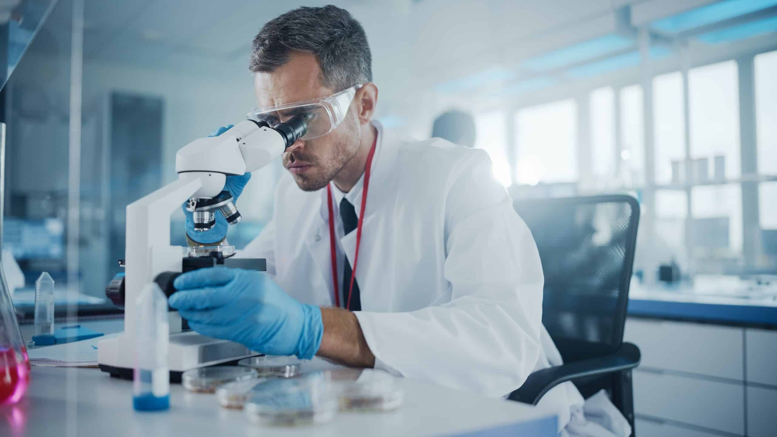 male researcher at microscope